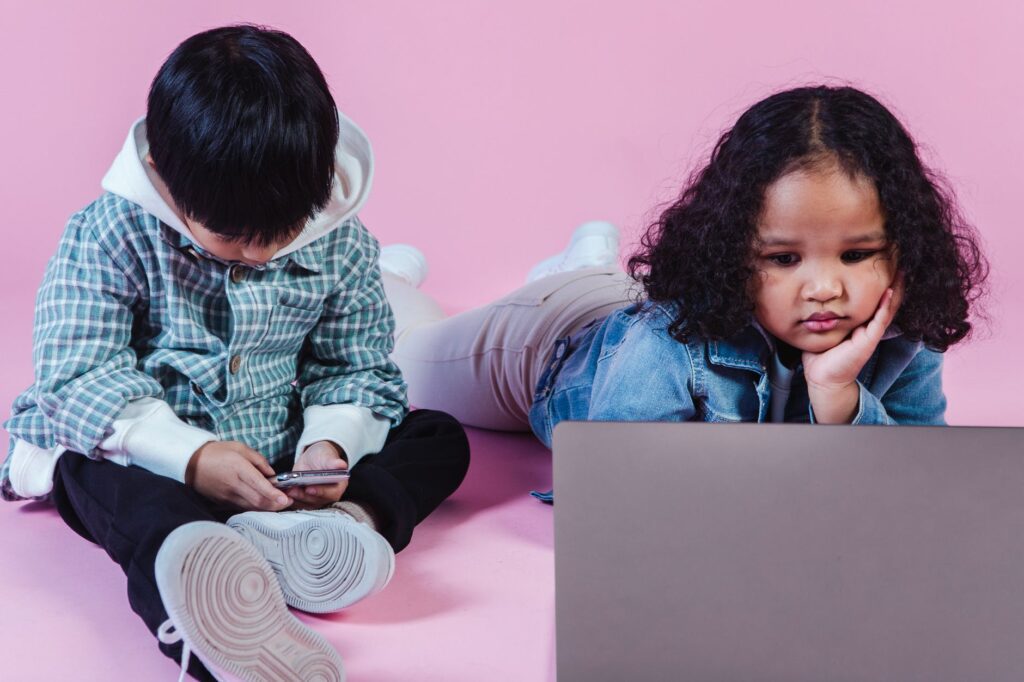multiracial children with laptop and phone in studio